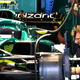 Mechanics work to rebuild an Aston Martin F1 car.
